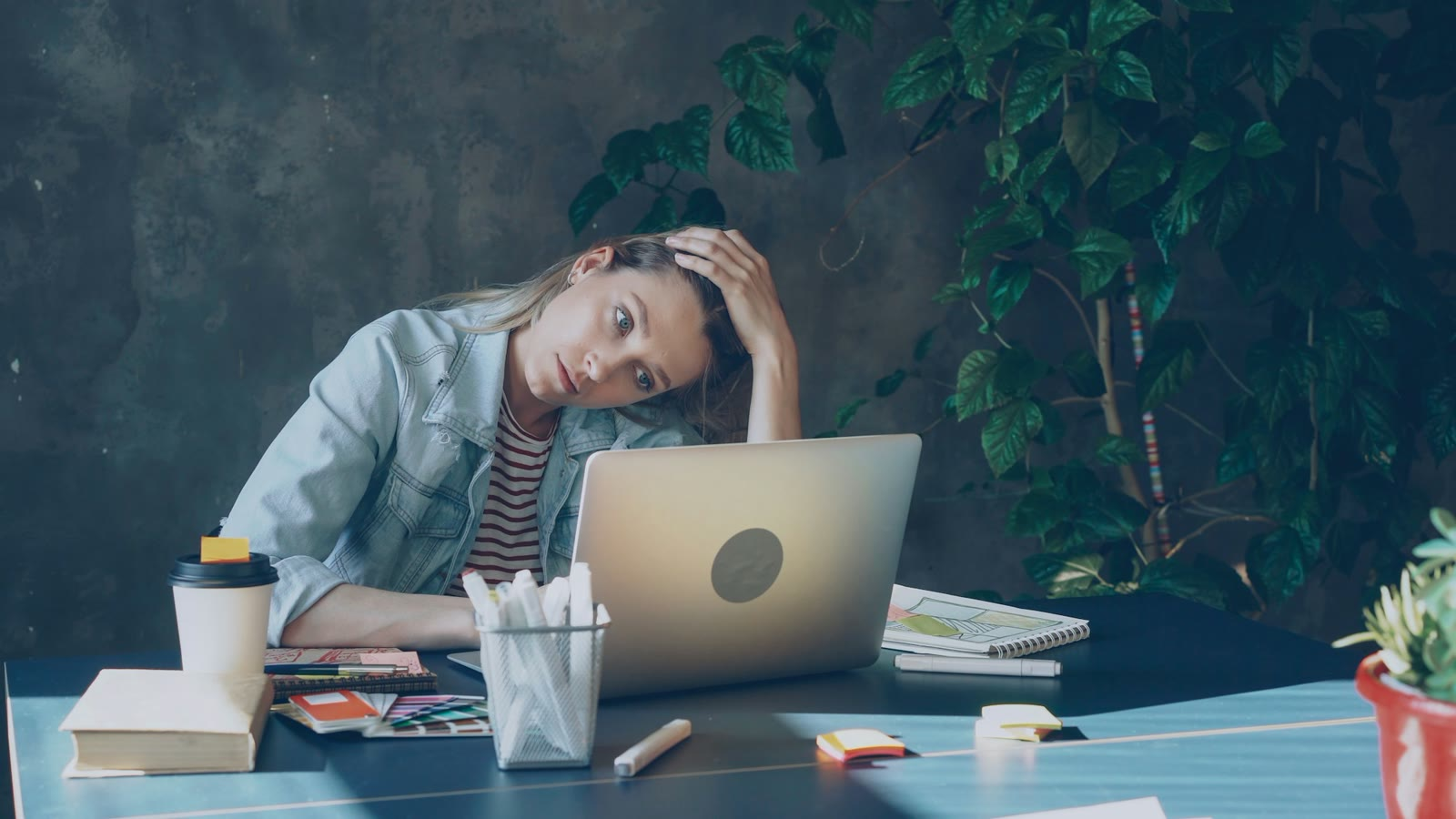 A woman exhausted at her laptop, trying to get through a PIP at work