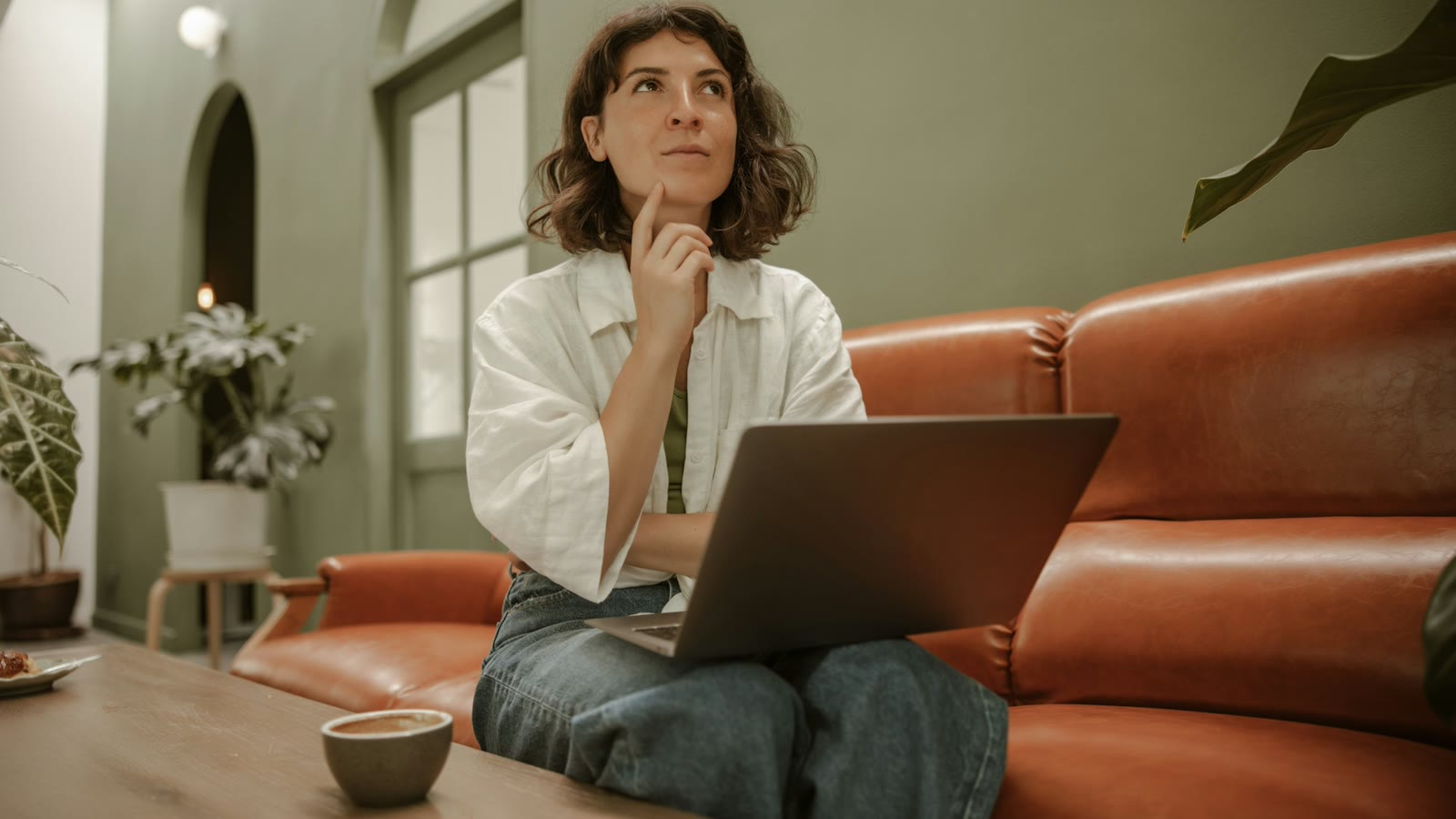 A woman on her couch with her laptop, weighing a counter offer